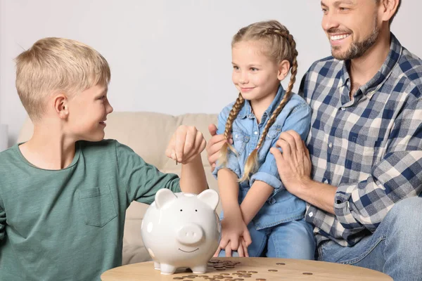 Szczęśliwa Rodzina Wprowadzenie Monet Piggy Bank Domu — Zdjęcie stockowe