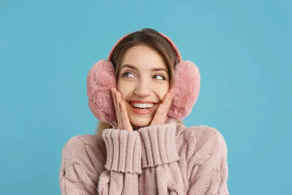 Glückliche Frau Mit Warmen Ohrenschützern Auf Hellblauem Hintergrund — Stockfoto
