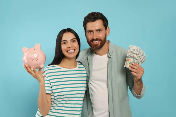 Gelukkig Paar Met Geld Keramische Spaarvarken Bank Lichtblauwe Achtergrond — Stockfoto