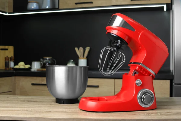 Modern stand mixer on wooden table in kitchen. Home appliance