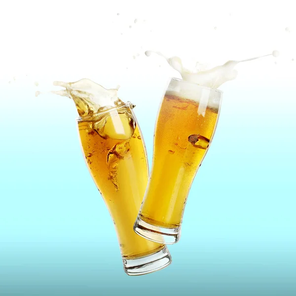 Two glasses of beer toasting with splash on color background