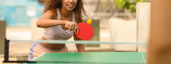 アフリカ系アメリカ人の女性が屋外で友人と卓球をしている バナーデザイン — ストック写真
