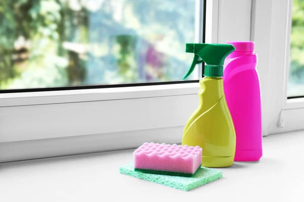 Cleaning supplies and sponges on window sill indoors, space for text