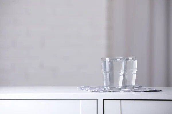 室内の白いテーブルの上に純水とメガネ テキストのためのスペース — ストック写真
