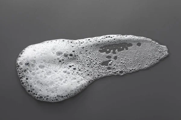 濃い灰色の背景に白い泡の汚れ トップビュー — ストック写真
