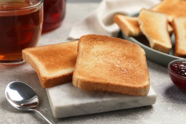 Açık gri masada lezzetli ekmek, reçel ve çay dilimleri