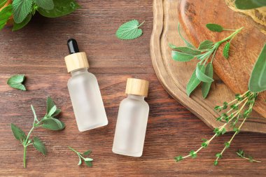 Ahşap masada, düz bir zeminde, gerekli yağlar ve taze bitkiler.