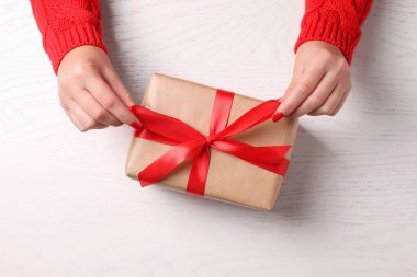 Noel hediyesi. Beyaz ahşap masadaki hediye kutulu kadın.