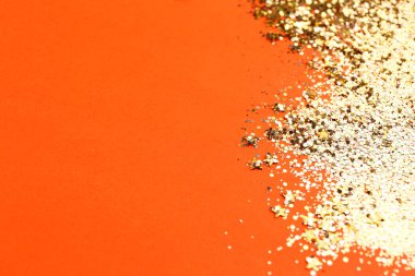 Shiny bright golden glitter on pale coral background. Space for text