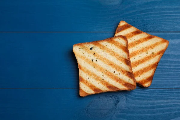 Φέτες Από Νόστιμο Φρυγανισμένο Ψωμί Μπλε Ξύλινο Τραπέζι Επίπεδο Lay — Φωτογραφία Αρχείου