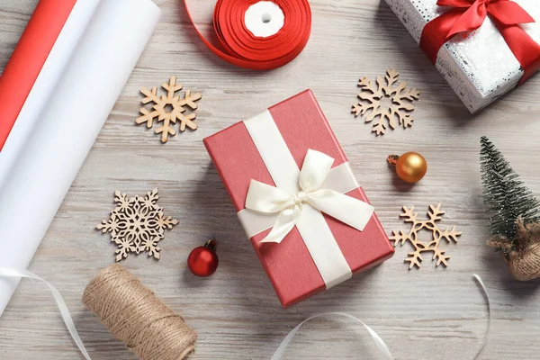 美しいクリスマスのギフトボックスと白い木製のテーブルの上に包装紙とフラットレイアウト組成物 — ストック写真