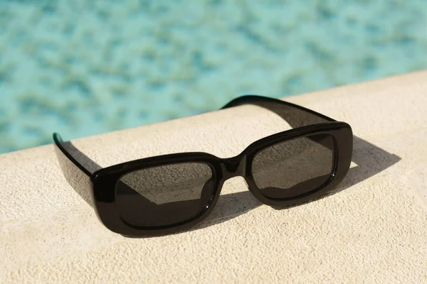 Stylové Sluneční Brýle Blízkosti Venkovního Bazénu Slunečného Dne Detailní Záběr — Stock fotografie