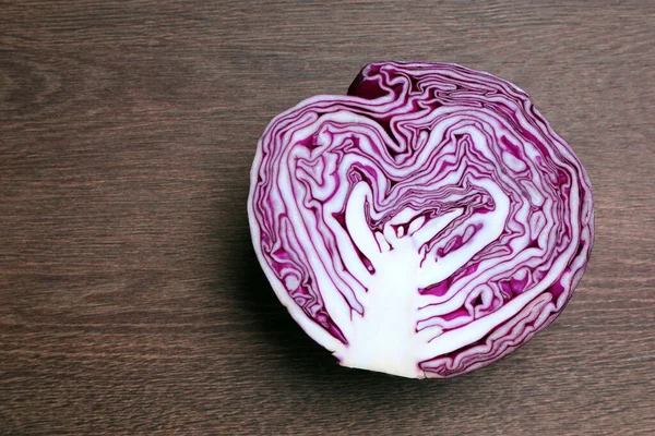 Half of fresh red cabbage on wooden table, top view. Space for text