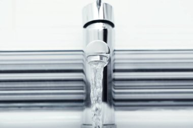 Stream of water flowing from tap in bathroom