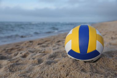 Denize yakın kumda renkli bir voleybol topu. Metin için boşluk