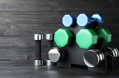 Siyah ahşap arka planda farklı dambıllarla dizilin