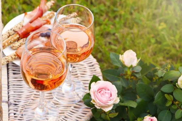 Flowers Glasses Delicious Rose Wine Food Picnic Basket Outdoors Closeup — стоковое фото