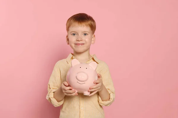 Netter Kleiner Junge Mit Keramik Sparschwein Auf Blassrosa Hintergrund — Stockfoto