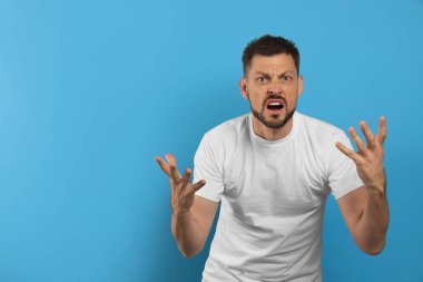 Açık mavi arka planda agresif adam, metin için boşluk