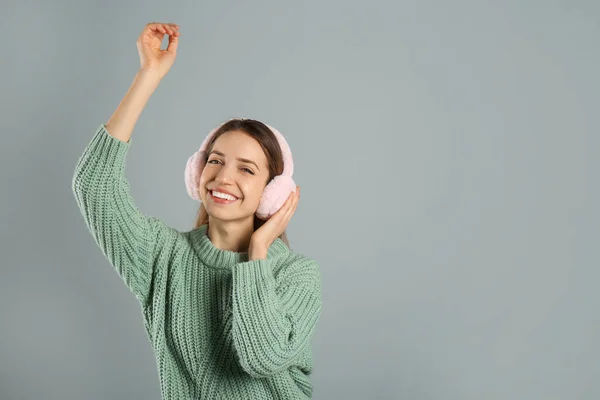 Ευτυχισμένη Γυναίκα Που Φοράει Ζεστά Ακουστικά Γκρι Φόντο Χώρος Για — Φωτογραφία Αρχείου