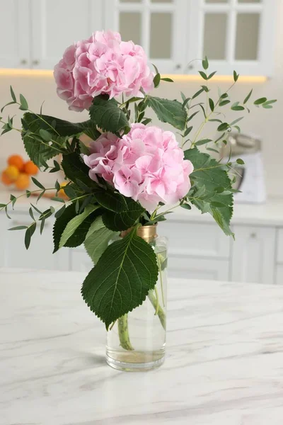 stock image Beautiful pink hortensia flowers in vase on kitchen table