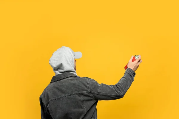 Hombre Sosteniendo Lata Pintura Aerosol Sobre Fondo Amarillo Vista Posterior — Foto de Stock