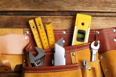 Emniyet kemeri ve ahşap masa üzerinde farklı aletler, üst görünüm