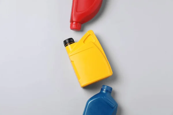 Motor oil in different canisters on light background, flat lay