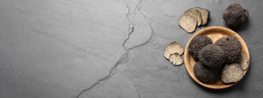 Gri masadaki siyah trüf mantarları, metin için yeri olan düz yataklar. Pankart tasarımı