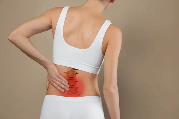 Mujer Que Sufre Dolor Espalda Sobre Fondo Beige Primer Plano —  Fotos de Stock