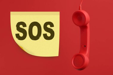 Telefon ahizesi kırmızı arkaplanda. Acil SOS çağrısı