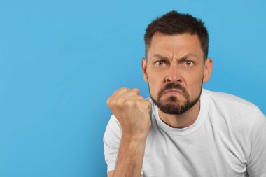 Açık mavi arka planda agresif adam, metin için boşluk