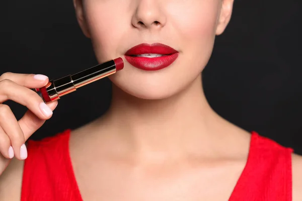 Mladá Žena Krásným Make Upem Drží Červenou Rtěnku Černém Pozadí — Stock fotografie