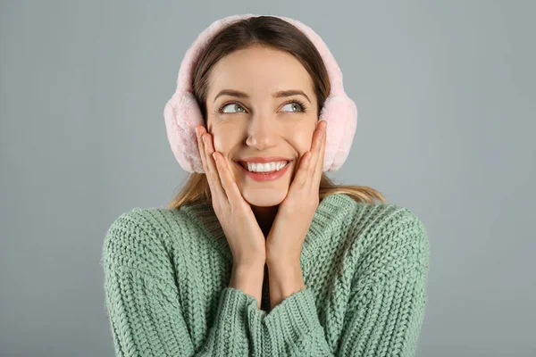 Ευτυχισμένη Γυναίκα Που Φοράει Ζεστά Ακουστικά Γκρι Φόντο — Φωτογραφία Αρχείου