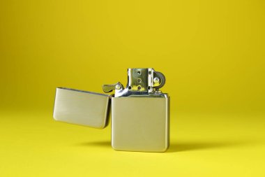 Sarı arka planda gri metalik çakmak, yakın plan.