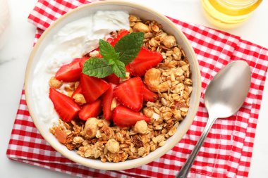 Lezzetli granola ve beyaz masada servis edilen malzemelerle bezenmiş düz bir kompozisyon. Sağlıklı yemek.