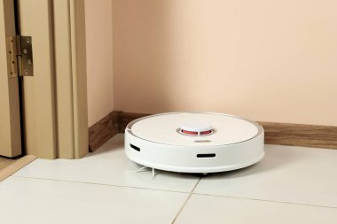 Beyaz zeminde modern robotik elektrikli süpürge.