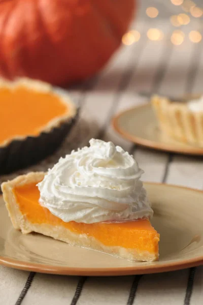 stock image Piece of fresh homemade pumpkin pie with whipped cream on table