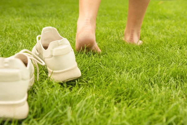Γυναίκα Αφήνοντας Παπούτσια Της Και Περπατώντας Ξυπόλητη Στο Πράσινο Γρασίδι — Φωτογραφία Αρχείου