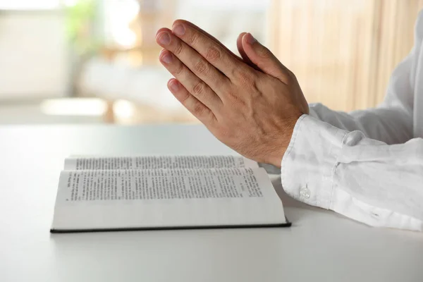 Άνθρωπος Βίβλο Προσεύχεται Λευκό Τραπέζι Στο Εσωτερικό Closeup — Φωτογραφία Αρχείου