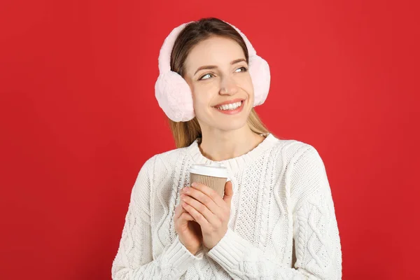Happy Woman Cup Drink Wearing Warm Earmuffs Red Background — Stock Photo, Image