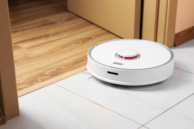 Beyaz zeminde modern robotik elektrikli süpürge.