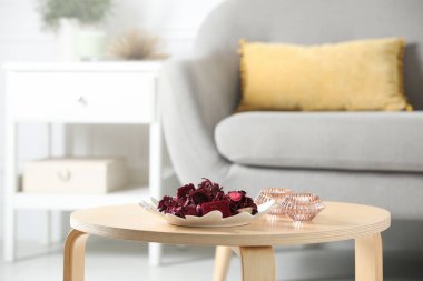 Kurumuş çiçeklerin ve kapalı bir sehpanın üzerindeki mumların aromatik potpurisi.