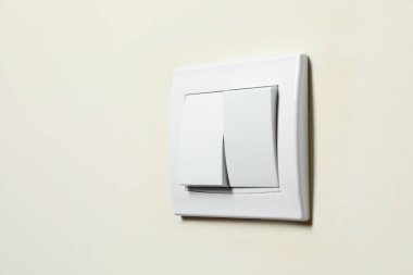 Modern plastik lamba anahtarı beyaz duvarda, yakın plan. Metin için boşluk