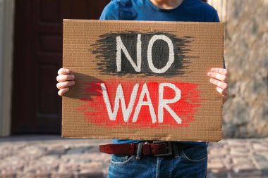 Man holding poster with words No War on city street, closeup clipart