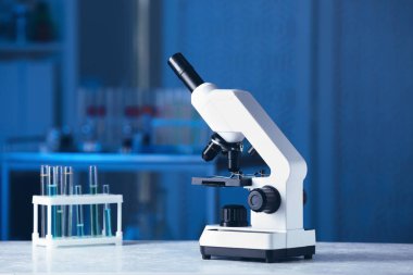 Laboratuvarda gri masada modern tıbbi mikroskop, metin için alan