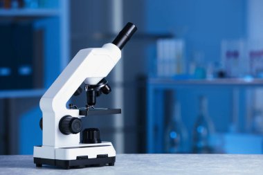 Laboratuvarda gri masada modern tıbbi mikroskop, metin için alan