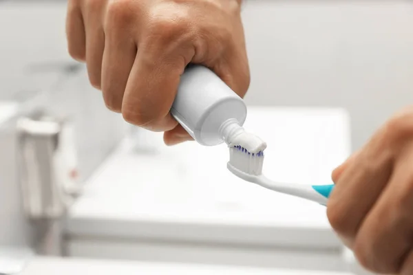 Mand Der Anvender Tandpasta Børste Badeværelset Closeup - Stock-foto