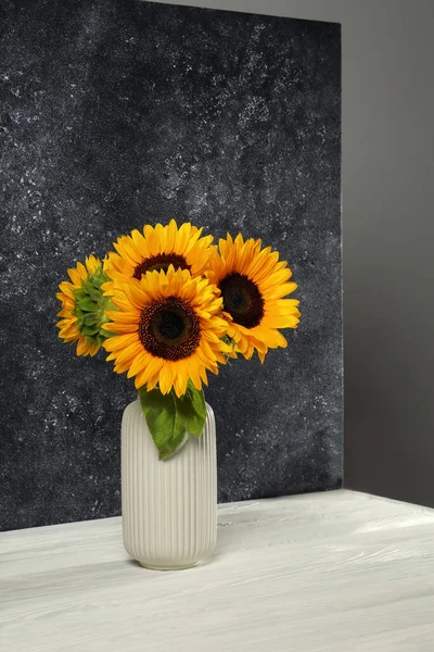 stock image Vase with beautiful sunflowers and double-sided backdrop in photo studio