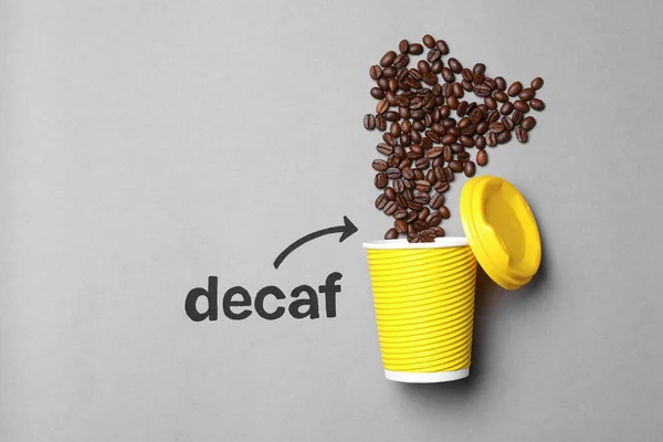 Woord Decaf Pijl Wijzend Afhaalpapier Beker Met Koffiebonen Lichtgrijze Achtergrond — Stockfoto